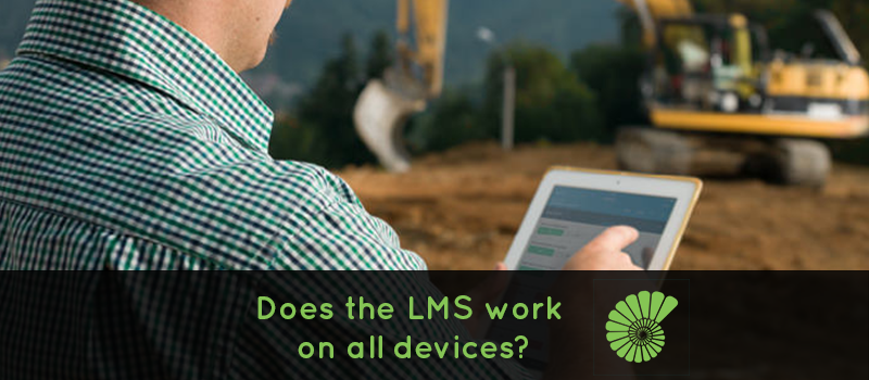 Construction worker on a worksite investigating an issue on an iPad with digger in the background text reads Does the LMS work on all devices with the Ammonite logo on the right hand side of the text
